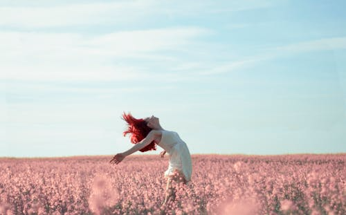 Blue sky, pinkish fields and a woman bending back exposing her whole heart to the heavens 