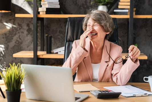 Very Happy woman with glasses off her nose and a big smile because she has completed her Tax Return 